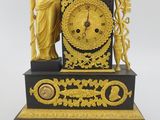 a gold and black clock with a statue on top of it