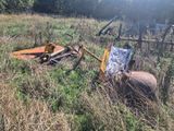 un tracteur immobilisé dans l'herbe, avec une charrue attelée derrière lui