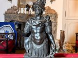 une statue représentant un homme assis sur une table