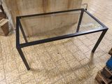 une table en verre surmontée d'un piètement métallique