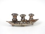 un plateau en argent avec trois bougies et un bateau