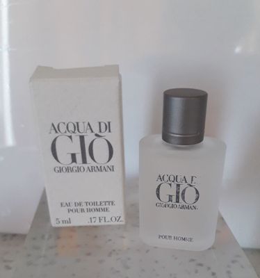 un flacon d'Acqua di Gio posé sur une table, à côté d'une boîte