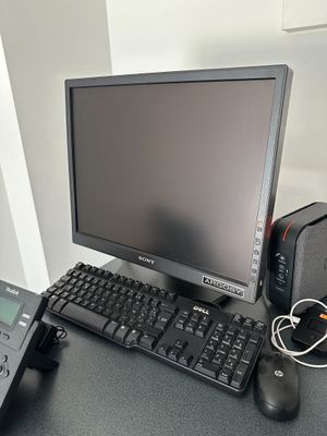 a desktop computer and a telephone on a desk