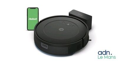 un aspirateur robot noir avec un téléphone à côté