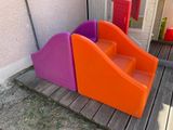 purple and orange play set on a wooden deck next to a house