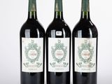 trois bouteilles de vin posées les unes à côté des autres sur une surface blanche