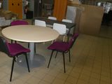 une table blanche et des chaises violettes dans une pièce