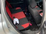 a panda bear sitting in the back seat of a car