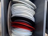 a lot of plates stacked in a box on the table