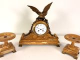 a clock and two candlesticks sitting on a table