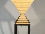 une sculpture en bois de forme géométrique posée sur un socle
