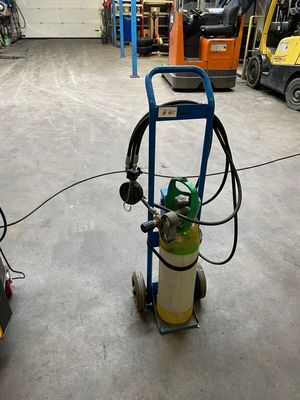a blue cart with a gas can on it in a warehouse