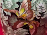 a vase with a butterfly painted on it on a red background