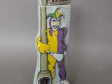une statue représentant un clown debout à côté d'une horloge