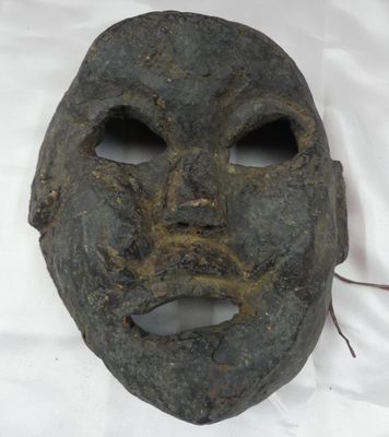 un vieux masque posé sur une table