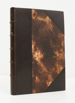 un gros plan d'un livre à la couverture marron posé sur une surface blanche