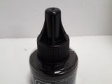 a bottle of ink sitting on a white table