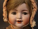 a close up of a doll with a bonnet on