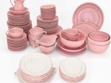 de nombreux plats, tasses et assiettes roses sur la table