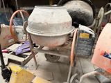 une bétonnière posée au milieu d'un tas de ferraille