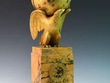 une statue représentant un oiseau avec une horloge sur la tête