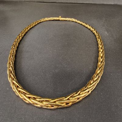un collier en or posé sur une surface noire