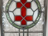 a stained glass window with a red cross on it