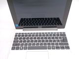 a white laptop with a black keyboard on a white table
