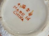 someone is holding a small white plate with a design on it