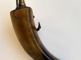 un objet en forme de corne posé sur une surface blanche