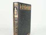 a black book with gold trim sitting on top of a white surface