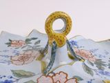 a plate with a handle that has a flower design on it