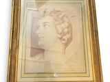 a framed picture of a woman ' s head in a gold frame