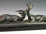 sculpture en bronze représentant deux cerfs couchés sur un socle en marbre