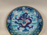 une assiette bleue ornée d'un dragon, posée sur une table