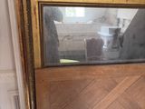 a large mirror sitting on top of a table next to a picture frame