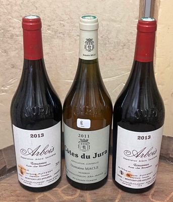 three bottles of wine sitting on a wooden table next to a bottle of wine