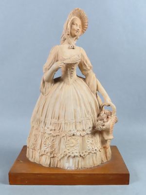 statue of a lady with a basket of flowers on a wooden base