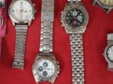 a lot of watches that are sitting on a red surface