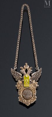 a silver necklace with a yellow and black emblem on it