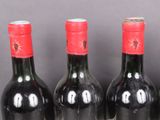 three bottles of wine are lined up in a row on a table