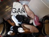 many pairs of shoes that are sitting on a bed