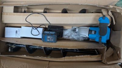 une boîte en carton posée par terre, contenant des outils