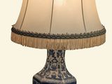 une lampe de table bleue et blanche, surmontée d'un abat-jour blanc