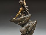 an image of a bronze statue of a woman sitting on a rock