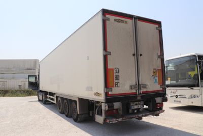 un camion blanc garé à côté d'un bus