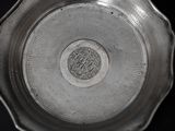 an antique silver plate with a decorative design on the rim