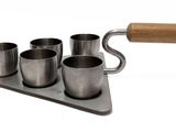 a metal tray with four cups and a wooden handle