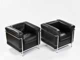 pair of black leather lounge chairs with chrome legs