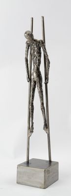 statue of a man holding a pair of skis on a wooden base